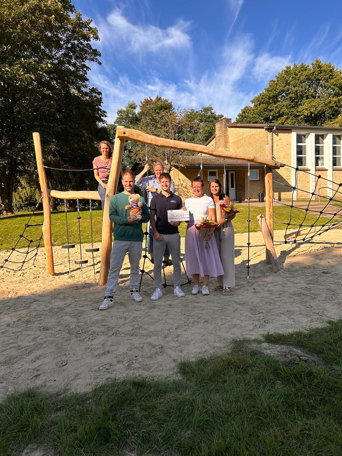 Mitglieder des Fördervereins der Schulen Hennstedt stehen vor dem neugebauten Kletterpfad.
